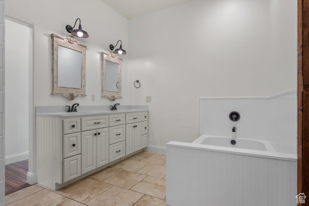Bathroom featuring double vanity and a bath