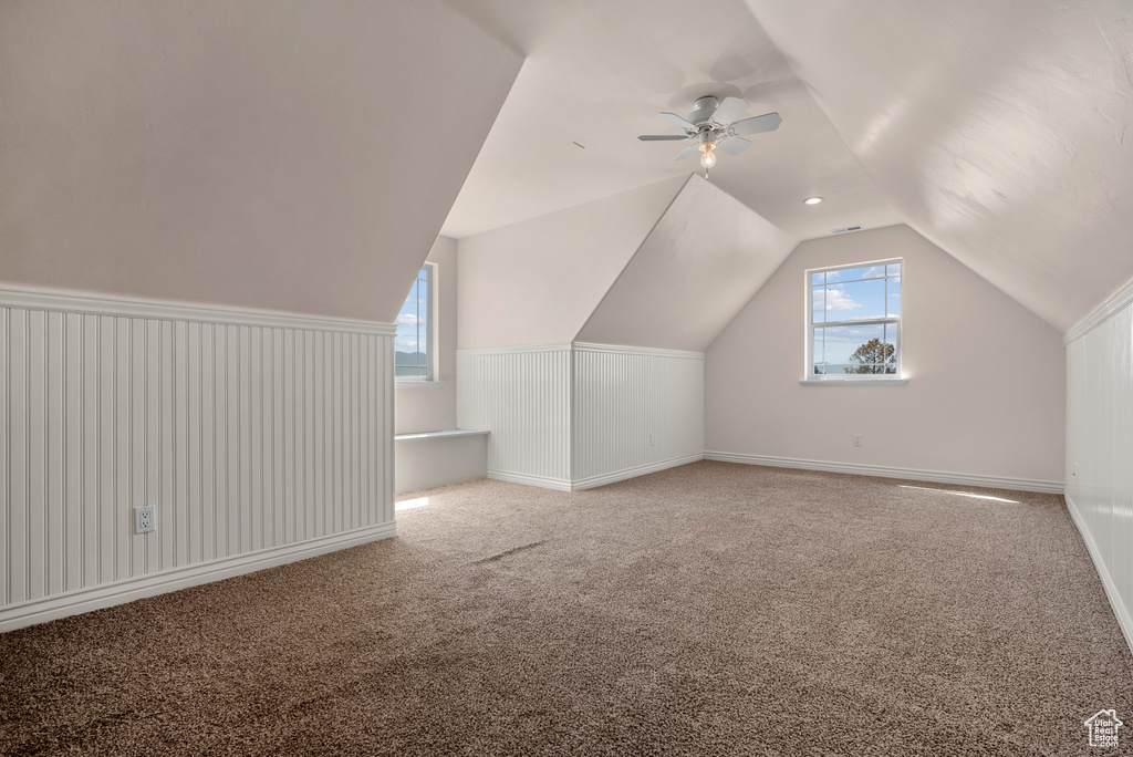 Bonus room with lofted ceiling, carpet flooring, and ceiling fan