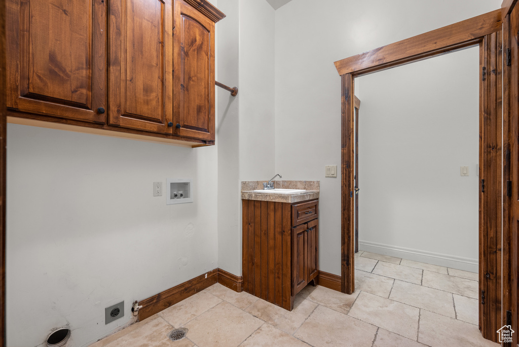 Washroom featuring cabinet space, electric dryer hookup, hookup for a washing machine, and light tile patterned floors