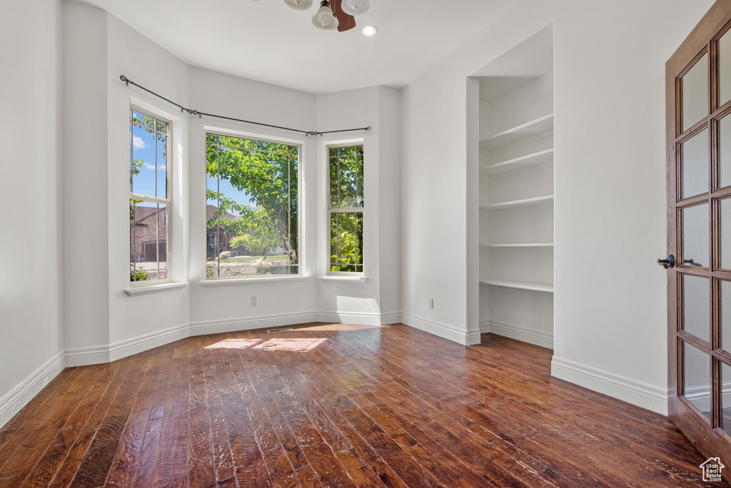 Unfurnished room featuring hardwood / wood-style floors and built in features