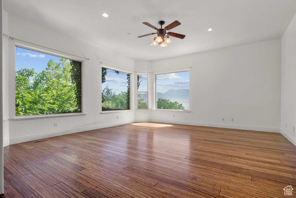 Empty room with a ceiling fan, recessed lighting, and wood finished floors