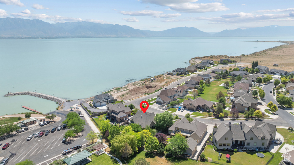 Aerial view of property and surrounding area featuring a water and mountain view and nearby suburban area