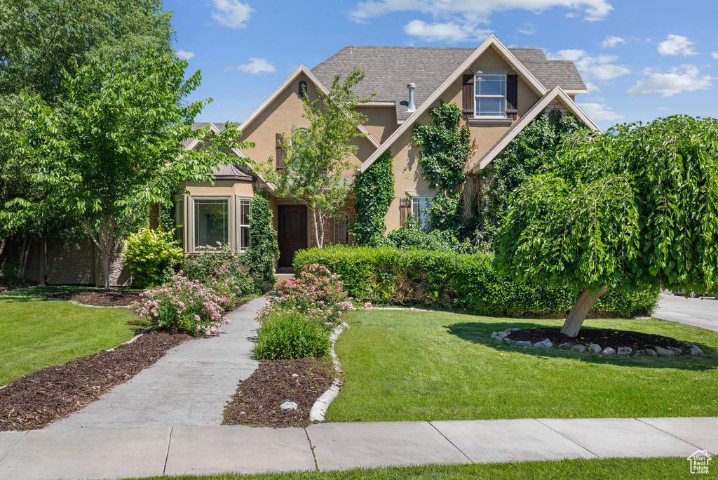 View of front of property featuring stucco siding and a front lawn