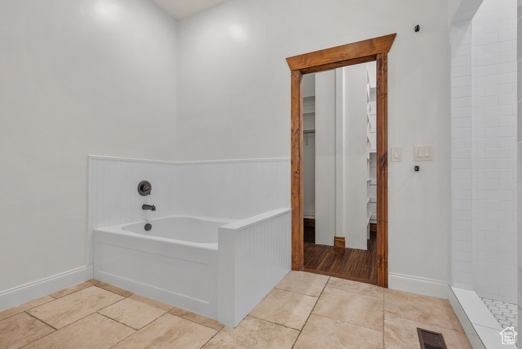 Bathroom with a bath, tile patterned floors, and a tile shower