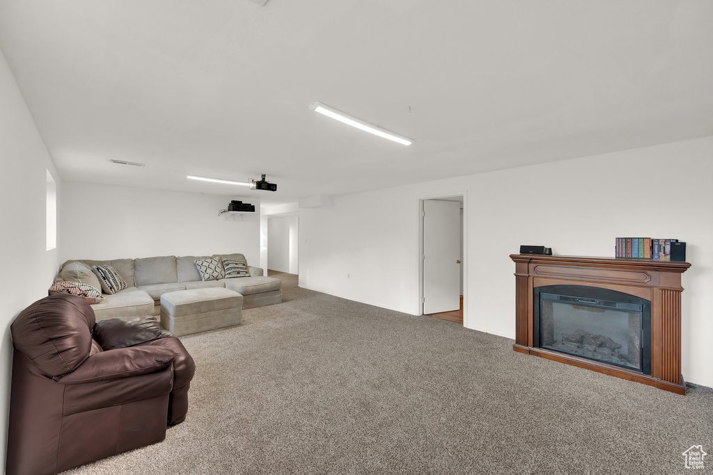 Living room with carpet floors and a glass covered fireplace