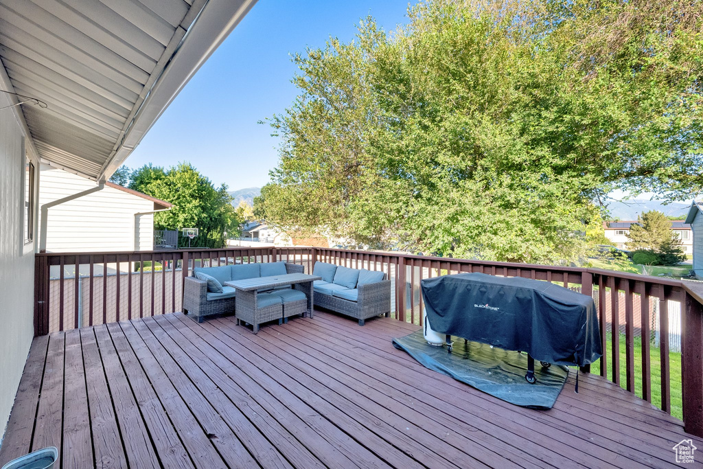 Wooden deck with outdoor lounge area, area for grilling, and a mountain view