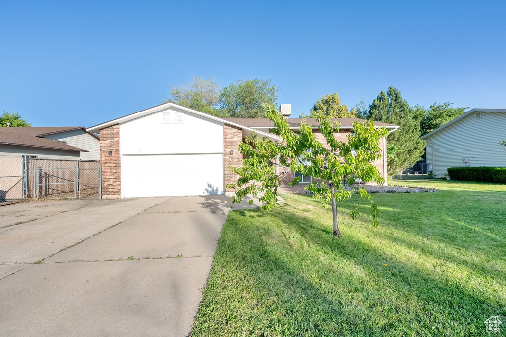 View of front of house with driveway, an attached garage, and brick siding