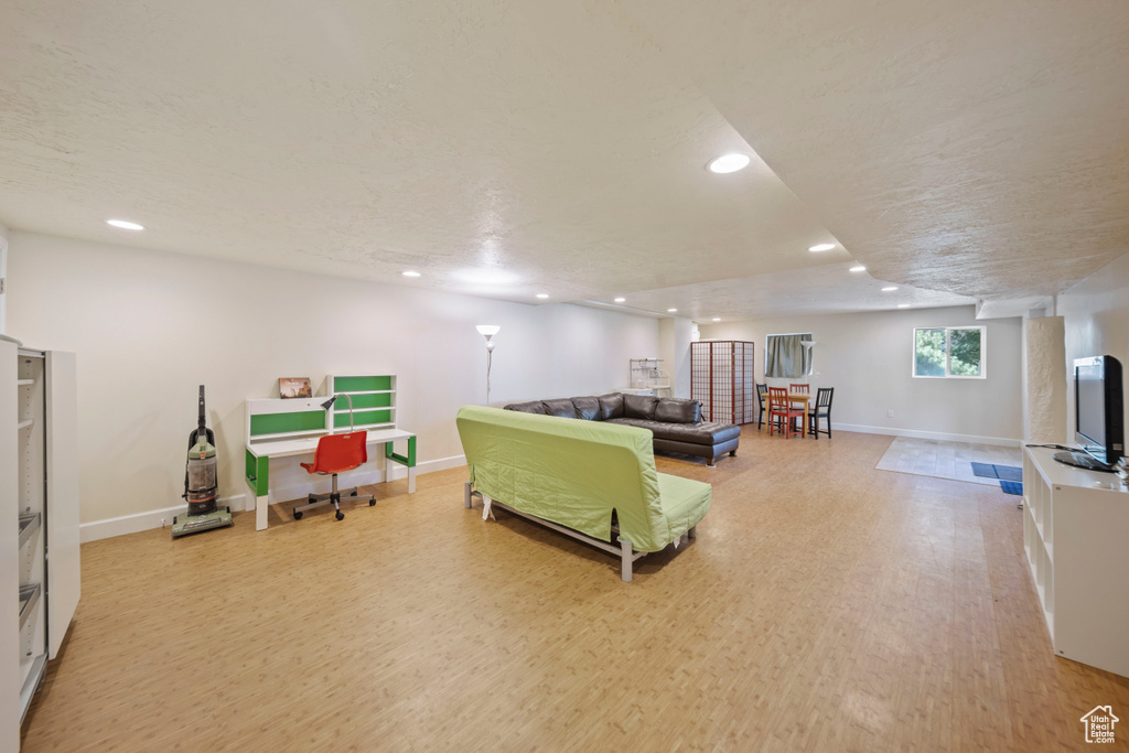Living area with light wood-style flooring and recessed lighting