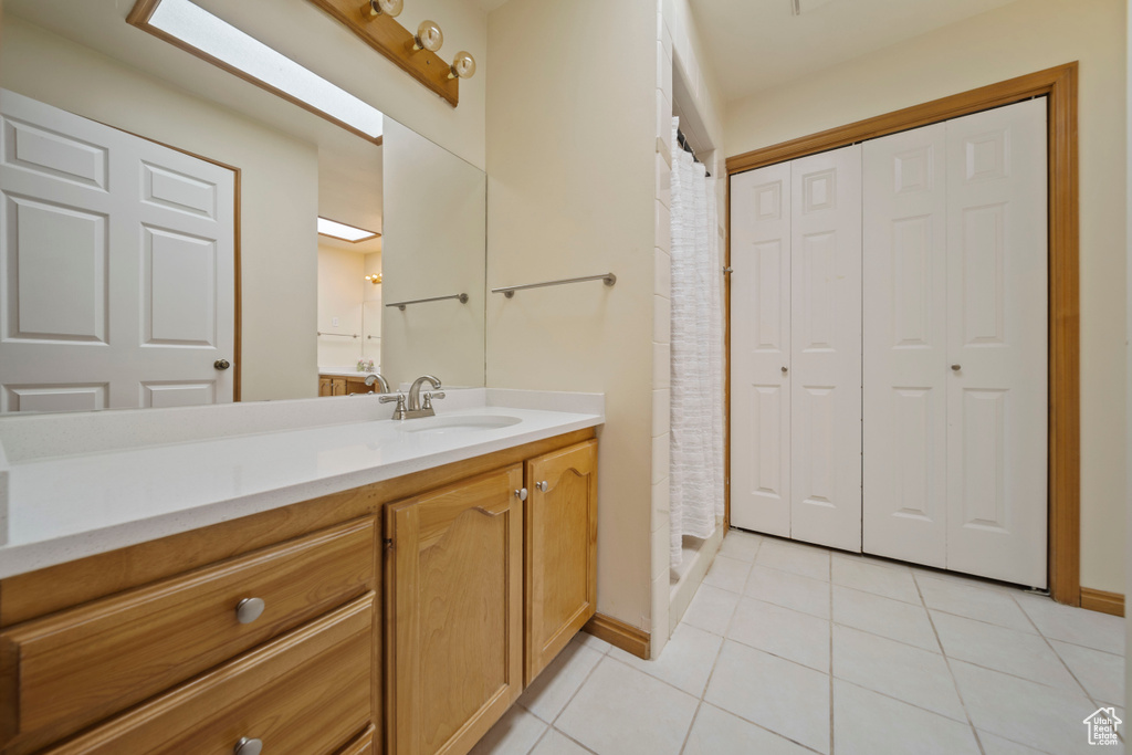 Bathroom featuring tile patterned floors, vanity, a closet, and curtained shower