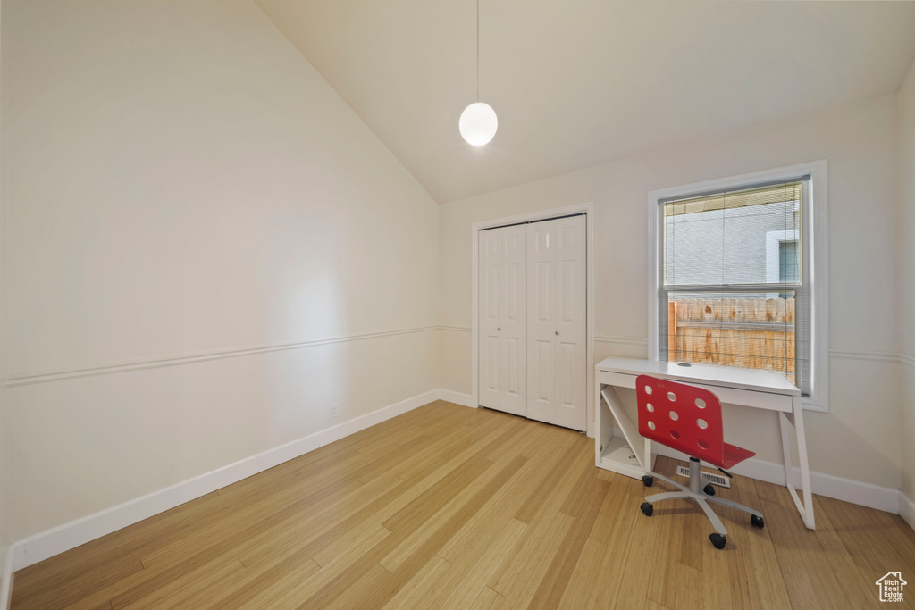 Office area featuring wood finished floors and vaulted ceiling