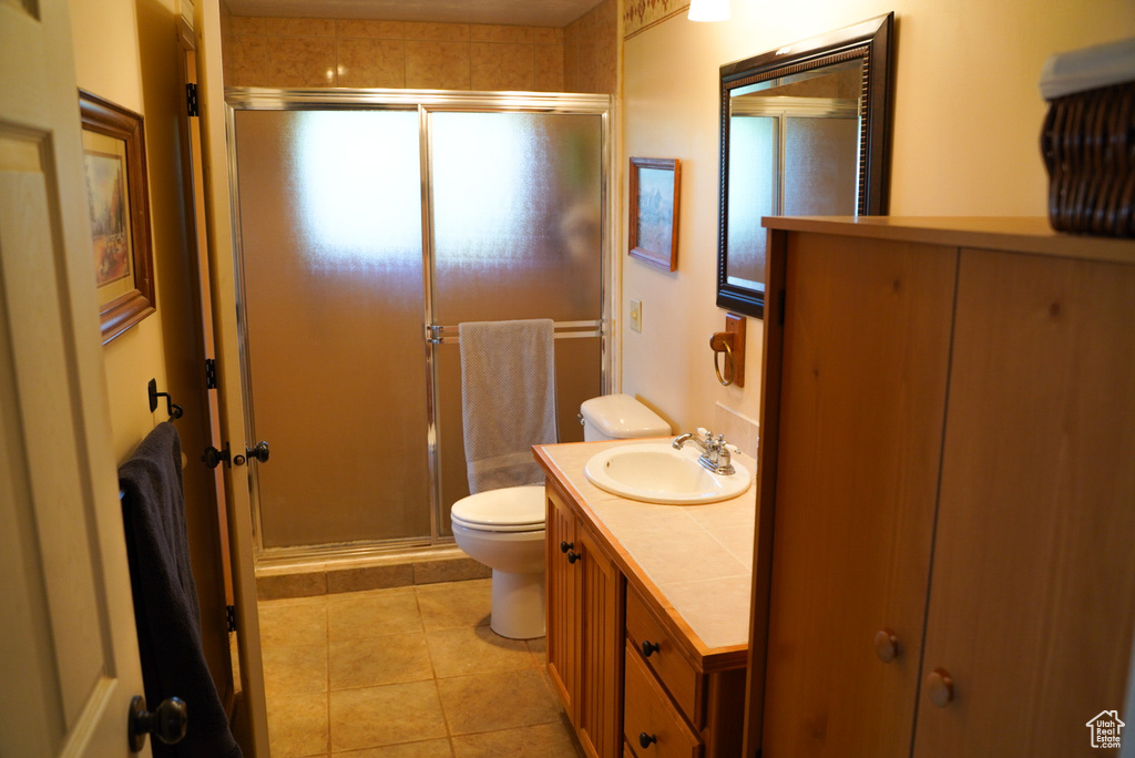 Full bathroom featuring a stall shower, vanity, and tile patterned flooring