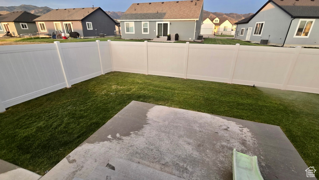 Fenced backyard with a residential view and a patio area