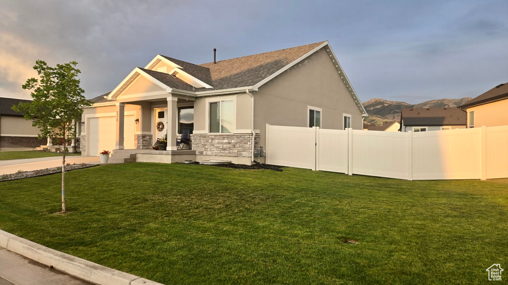 View of front facade with an attached garage, stucco siding, stone siding, a porch, and a shingled roof