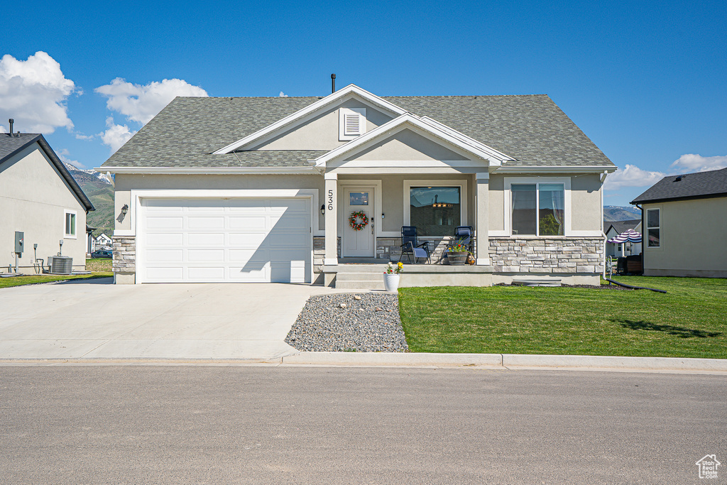 View of front facade featuring a porch, stone siding, and stucco siding