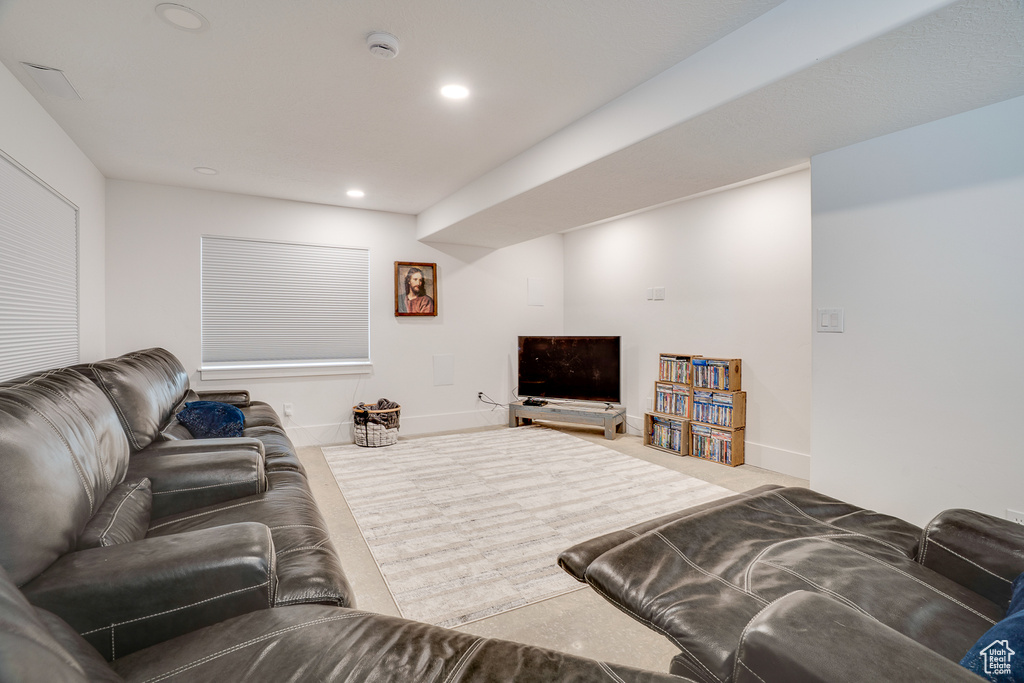 Carpeted living area with recessed lighting and baseboards