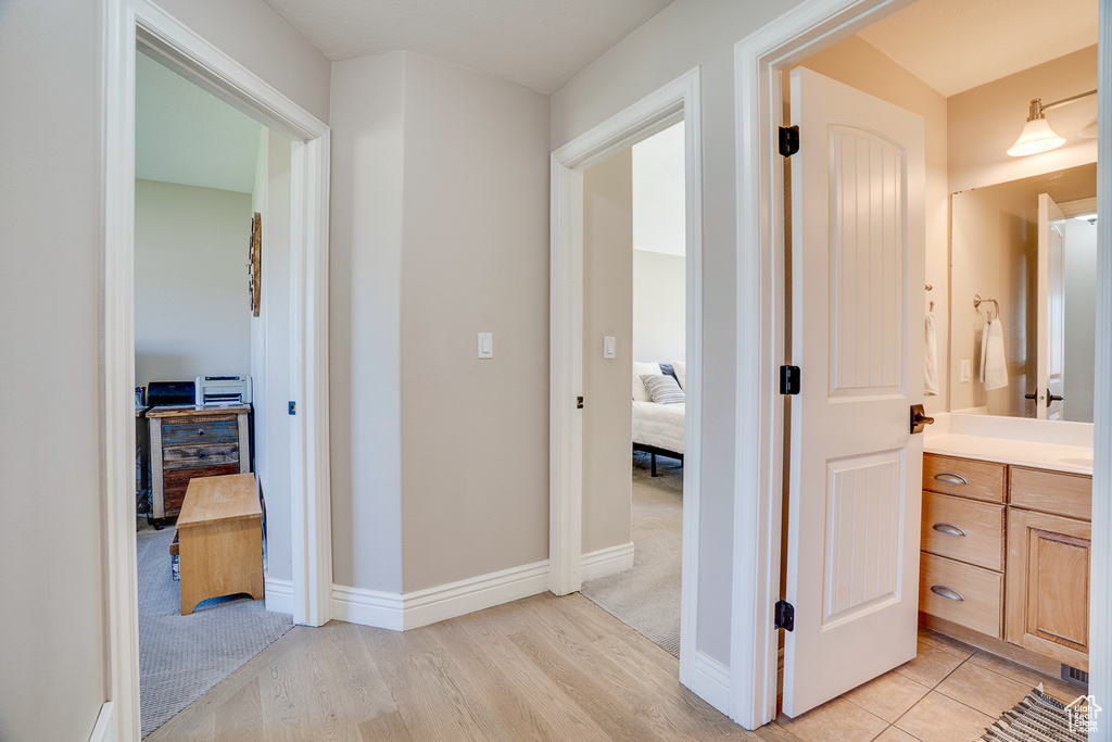 Corridor featuring light wood-style flooring and baseboards
