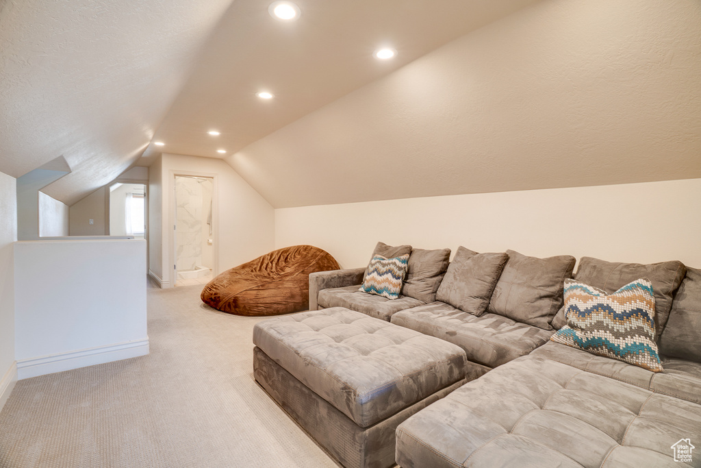 Living room featuring light carpet, vaulted ceiling, and recessed lighting
