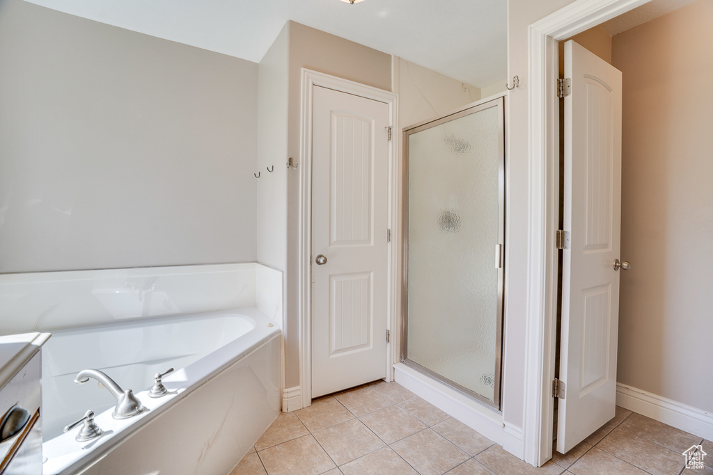 Full bath with tile patterned flooring, a stall shower, and a bath