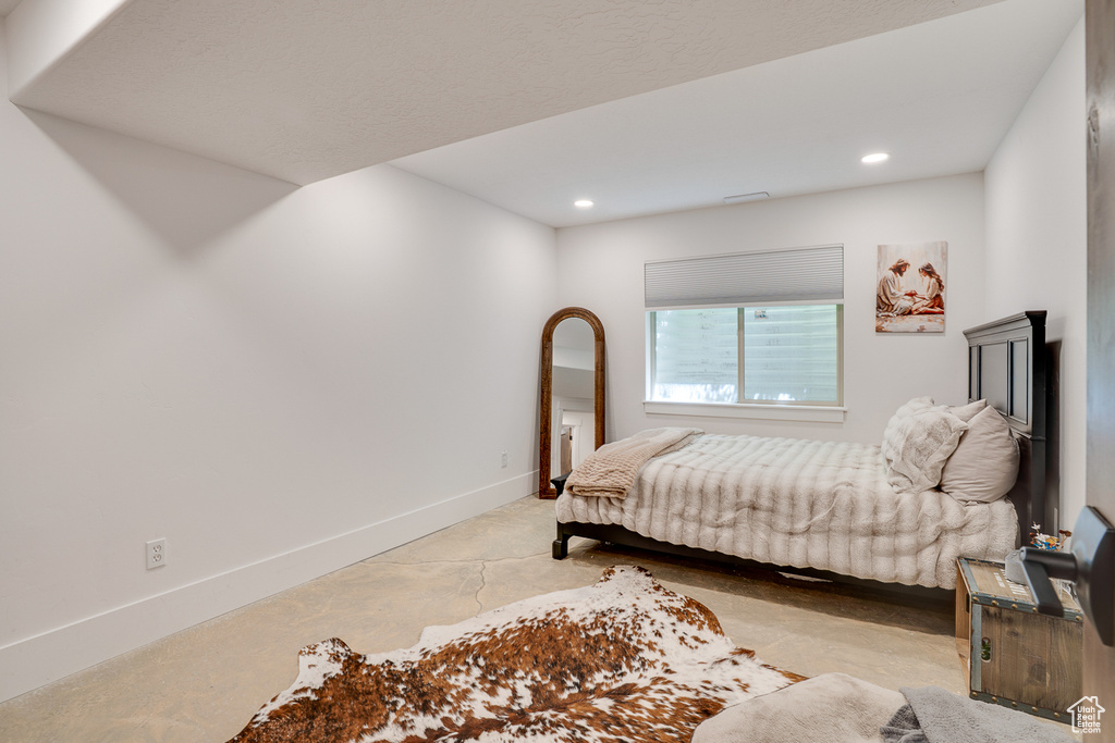 Bedroom with recessed lighting and concrete floors