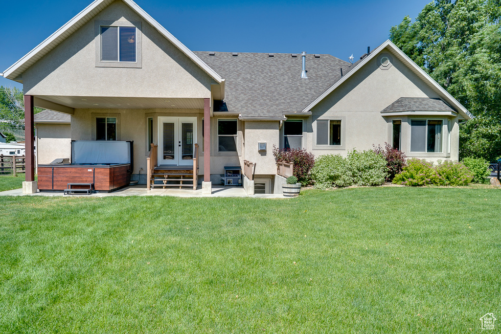 Back of house with a hot tub, french doors, a shingled roof, and stucco siding