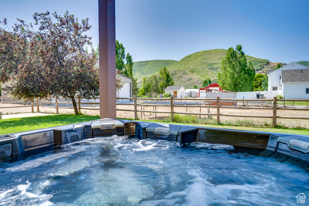 View of patio / terrace with a hot tub and a mountain view