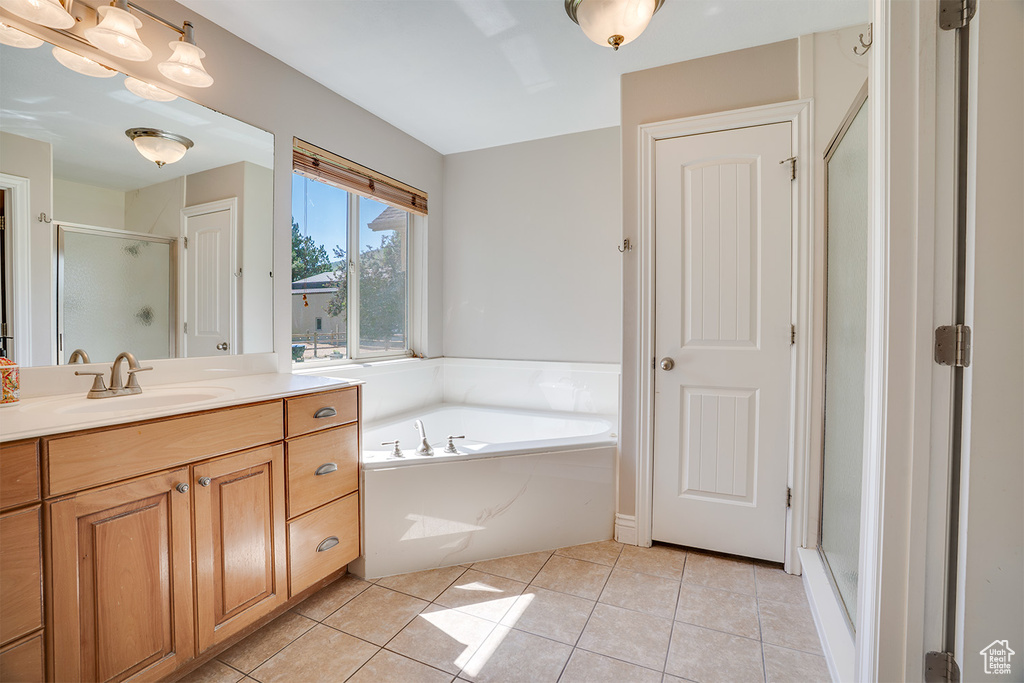 Bathroom with vanity, a shower stall, a bath, and tile patterned floors