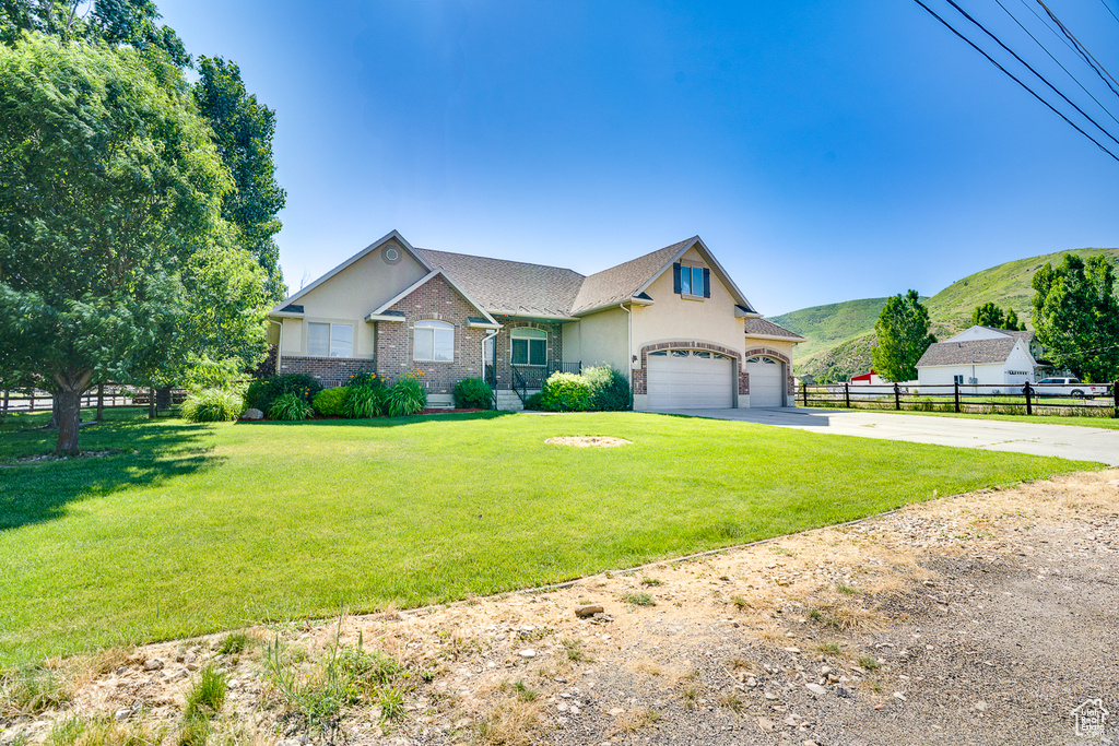 View of front of home featuring concrete driveway, a mountain view, and stucco siding