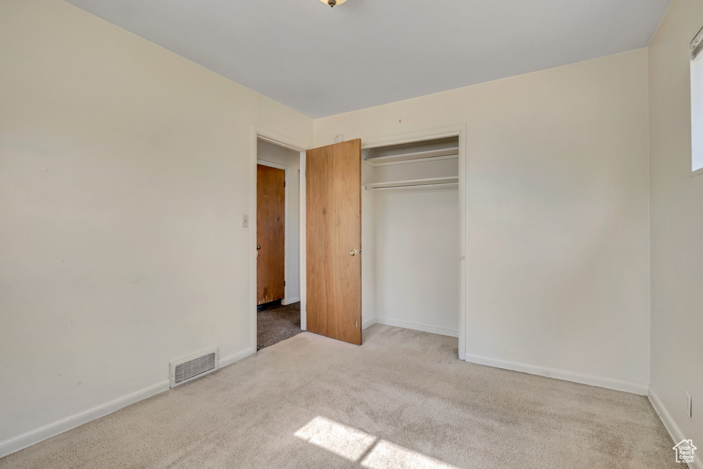 Unfurnished bedroom featuring carpet floors and a closet
