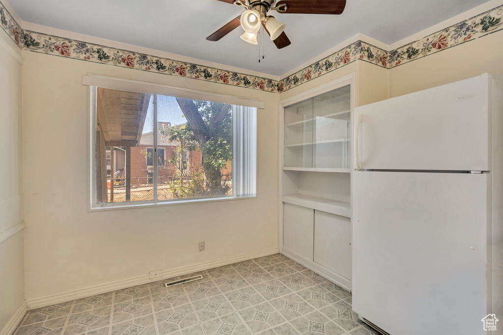 Unfurnished dining area featuring ceiling fan and baseboards