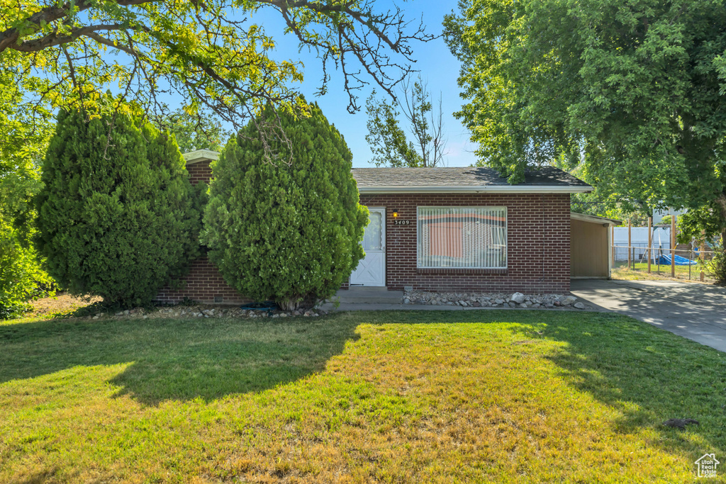View of front of home featuring brick siding, driveway, and an attached carport