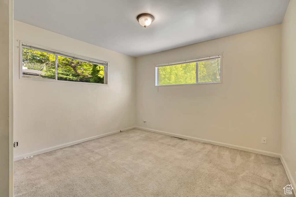 Carpeted spare room featuring baseboards