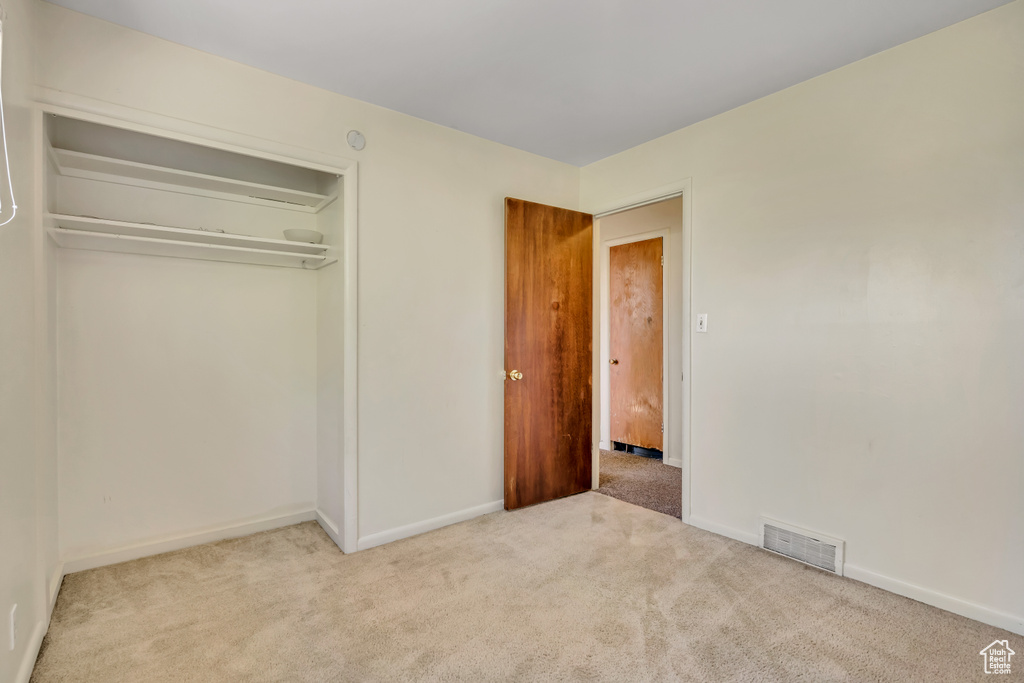 Unfurnished bedroom featuring carpet floors and a closet