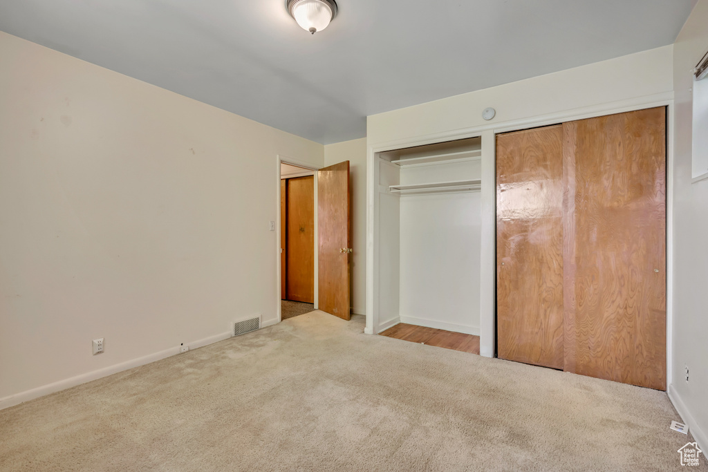 Unfurnished bedroom featuring carpet flooring and two closets