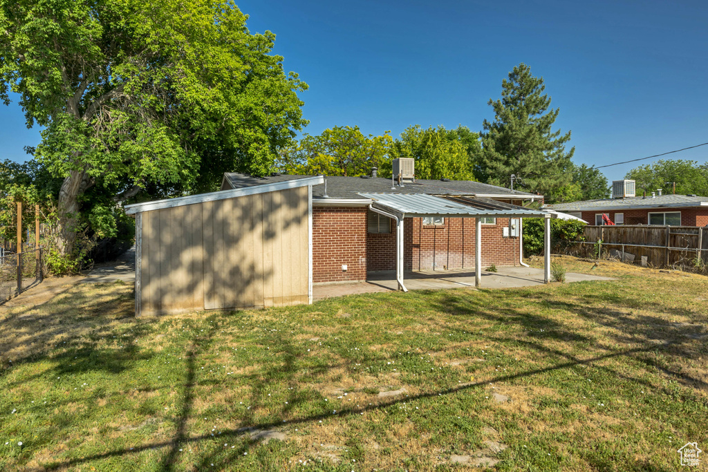 Rear view of property featuring a patio, brick siding, and a fenced backyard