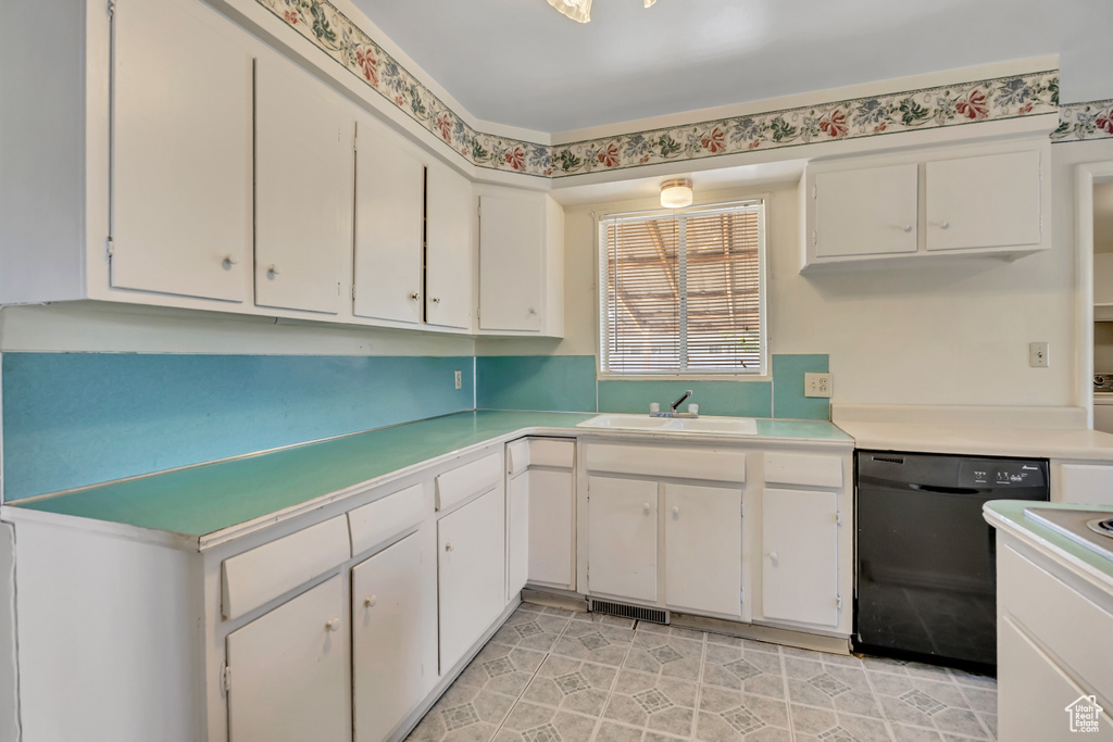 Kitchen with dishwasher, light countertops, and white cabinets