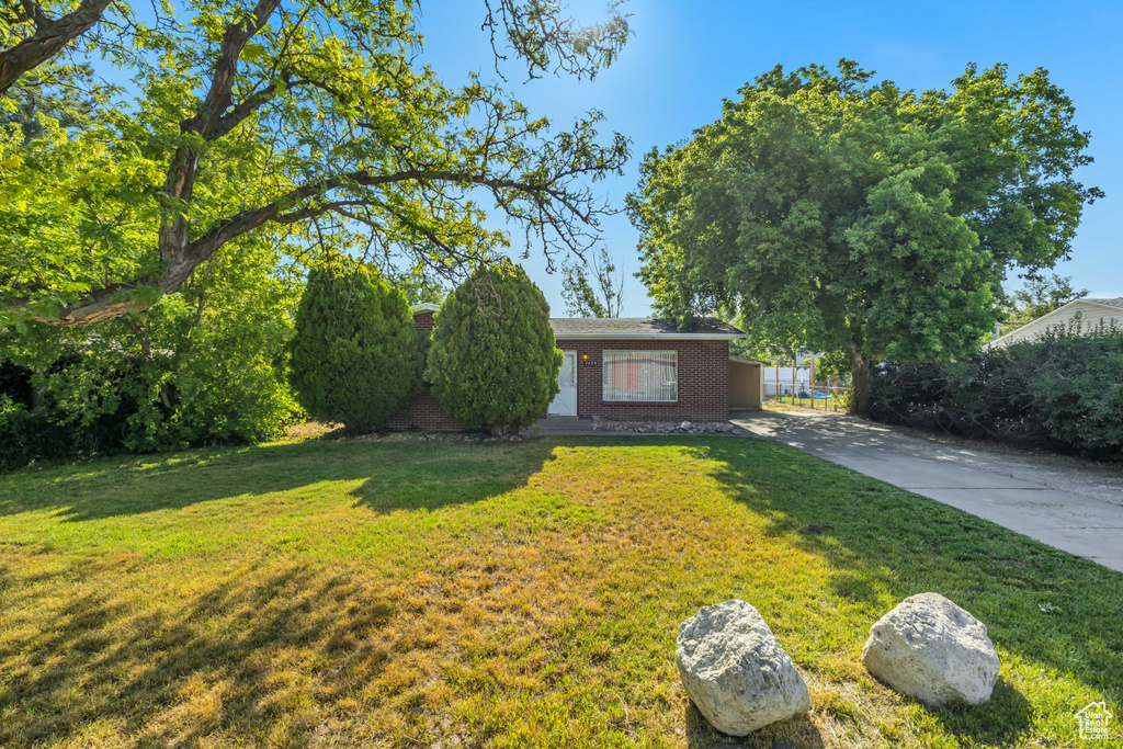 View of front facade featuring brick siding, a front lawn, and concrete driveway