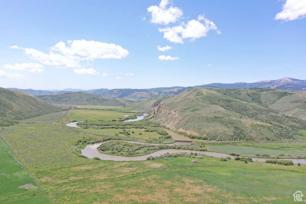 View of mountain background featuring a nearby body of water and rural landscape