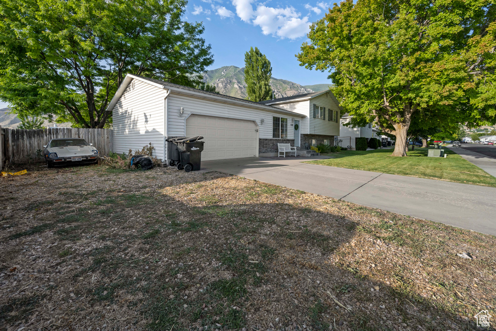Tri-level home with an attached garage, a mountain view, and driveway