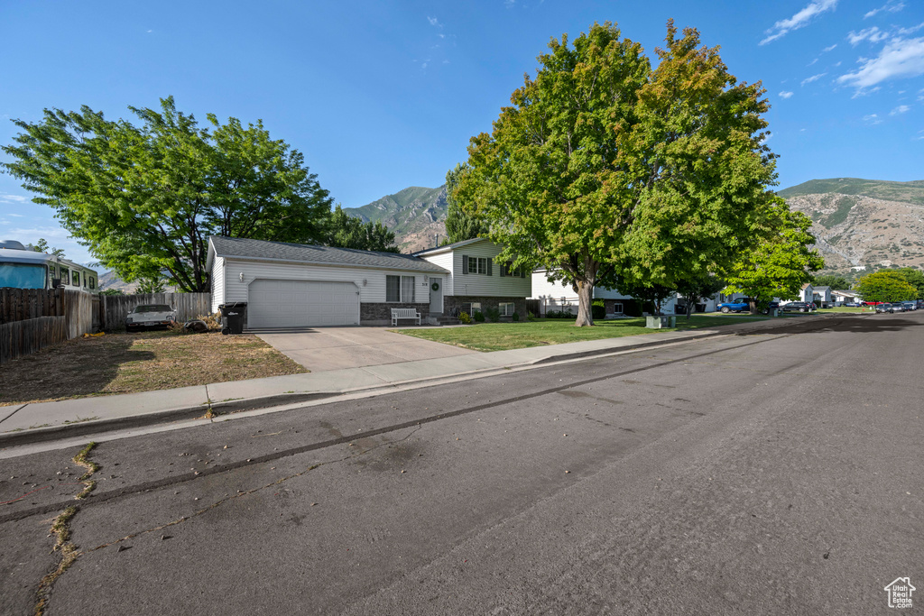 Split level home featuring a mountain view, a garage, and driveway