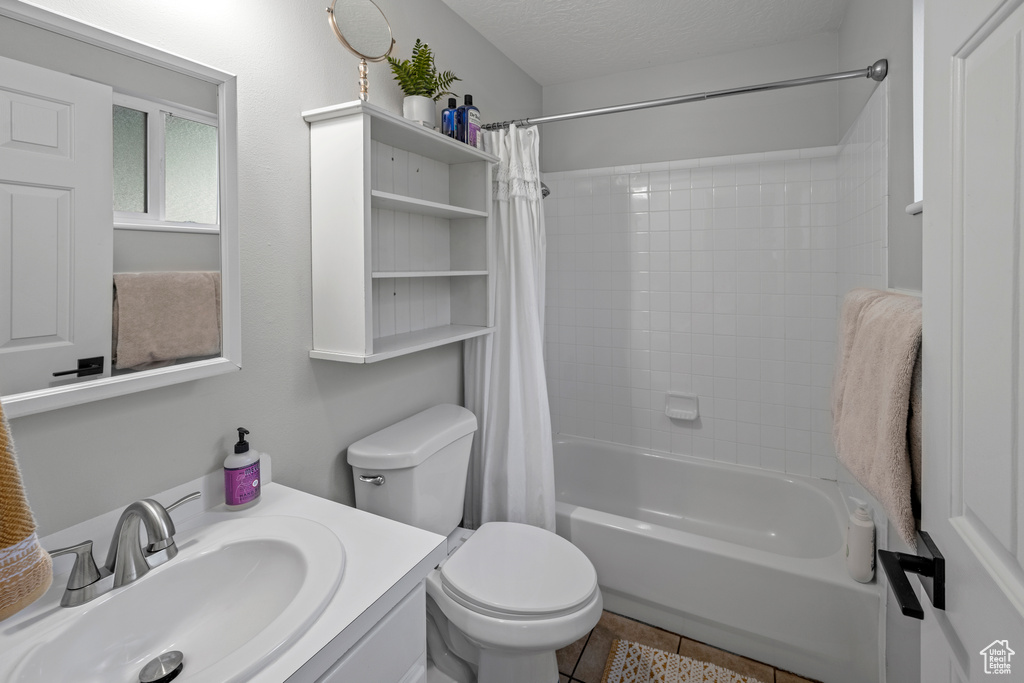 Full bathroom with shower / tub combo, vanity, and tile patterned flooring