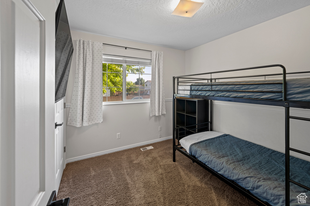 Unfurnished bedroom featuring carpet floors and a textured ceiling