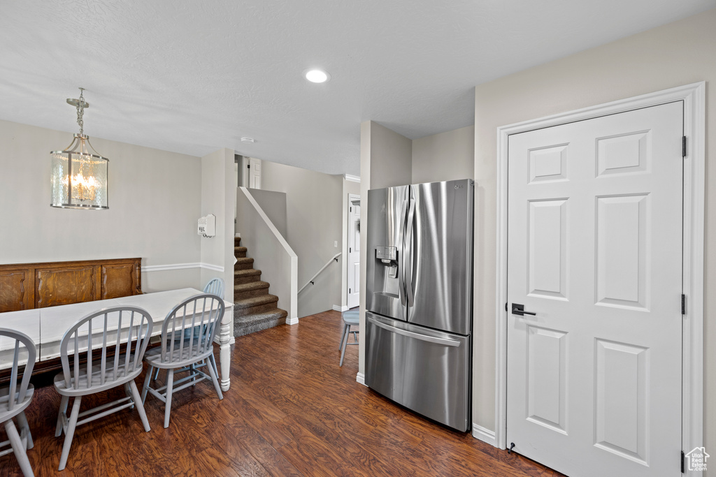 Kitchen featuring stainless steel refrigerator with ice dispenser, dark wood-type flooring, pendant lighting, recessed lighting, and a chandelier