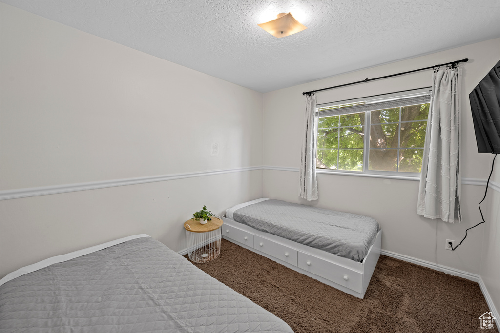 Bedroom featuring a textured ceiling and carpet flooring