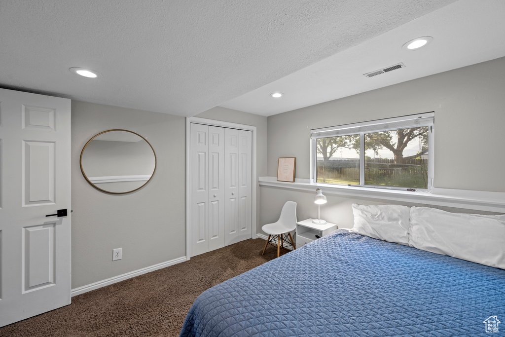 Bedroom with carpet floors, recessed lighting, a textured ceiling, and a closet