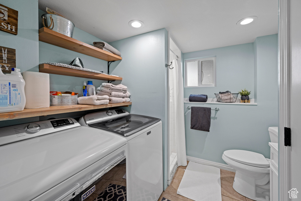 Laundry room featuring washing machine and dryer, light tile patterned floors, and recessed lighting