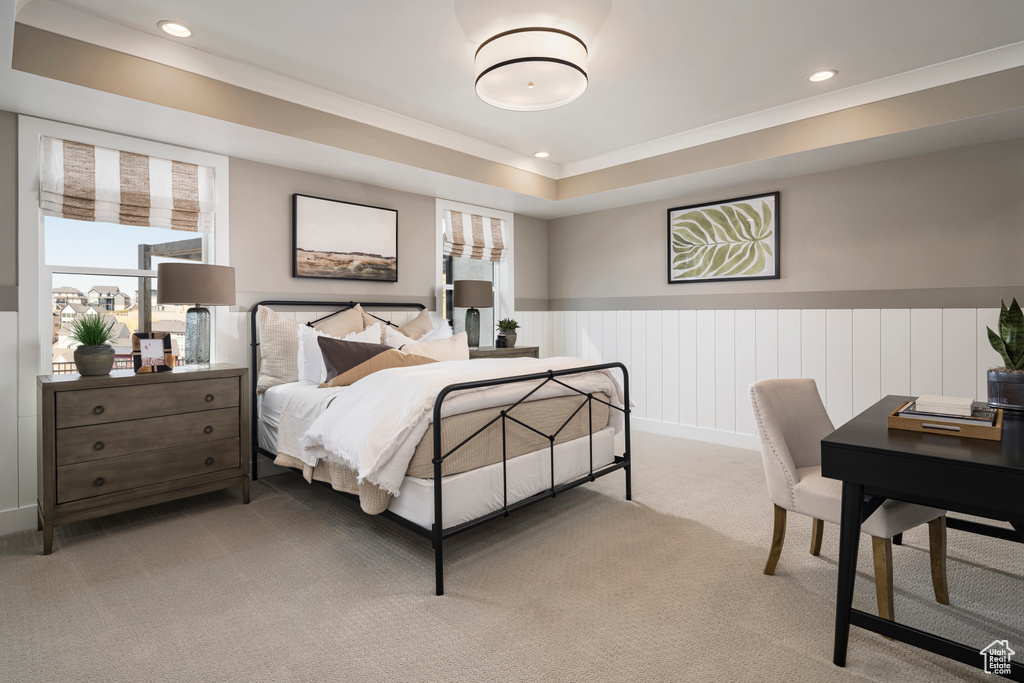 Bedroom with recessed lighting, light carpet, wainscoting, ornamental molding, and a tray ceiling