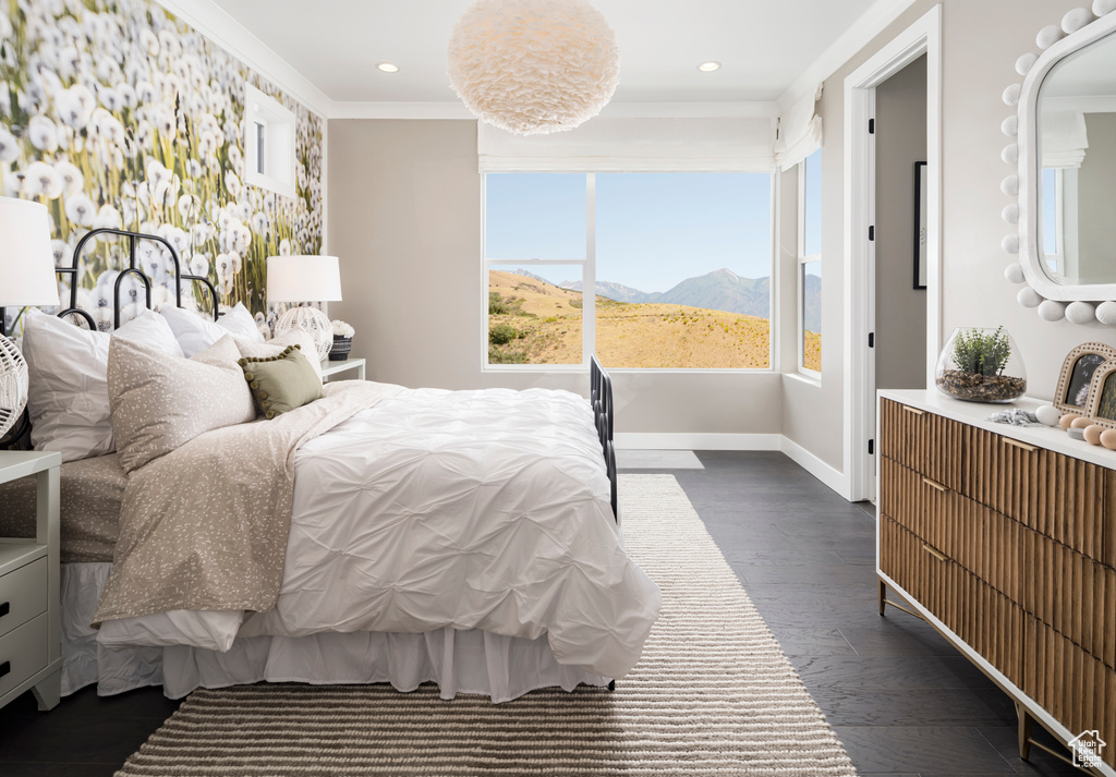 Bedroom with a mountain view, dark wood finished floors, recessed lighting, and crown molding