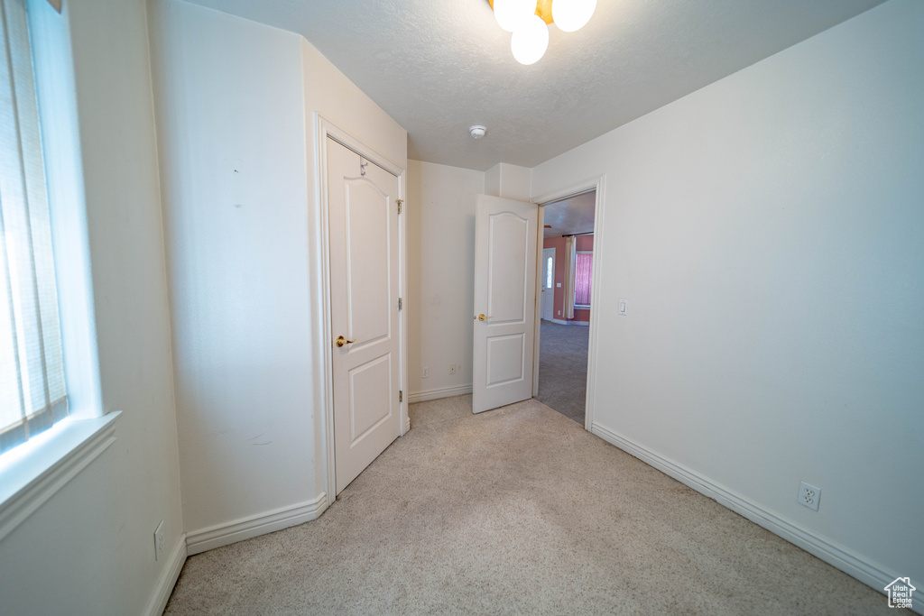 Unfurnished bedroom featuring carpet and a textured ceiling