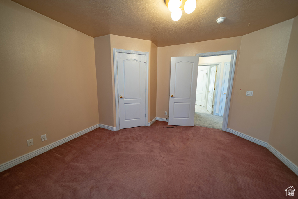 Unfurnished bedroom featuring carpet flooring and a textured ceiling