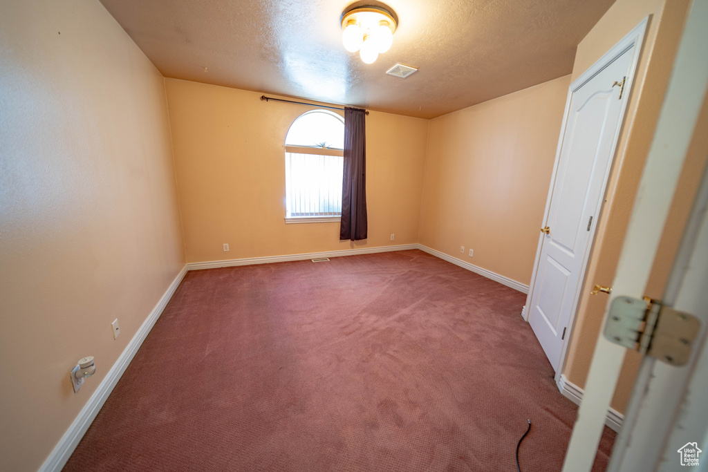 Unfurnished bedroom featuring carpet floors and a textured ceiling